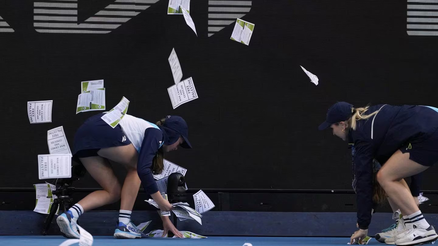 Ball kids pickup "free Palestine" leaflets thrown onto Margaret Court Arena during the fourth round match between Alexander Zverev of Germany and Cameron Norrie of Britain at the Australian Open. Photo / AP