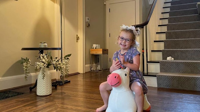 Brynn Schulte rides on a toy unicorn at her home in Cincinnati shortly before getting medication to treat her rare genetic bleeding disorder. Photo / AP