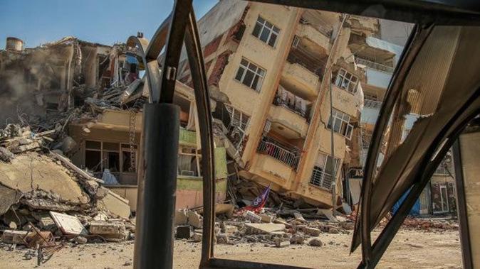 A building destroyed in the massive earthquake this month leans on a neighbouring house in Samandag, southern Turkey. Photo / AP
