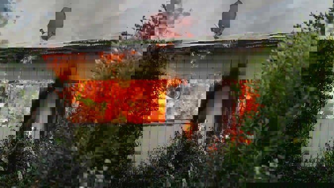 Flames leap from the house on Rawhiti Rd, Manly. Photo / Supplied