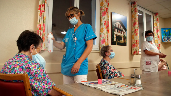 A health worker refreshes a resident at a retirement home in Isturitz, France, in June 2022 during a deadly heatwave. Bob Edme/AP/FILE