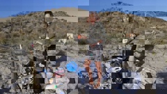 Papamoa Beach resident Sophie Lister with some of the rubbish found in the sane dunes after by beach partygoers on November 26. Photo / Bruce Hutchinson
