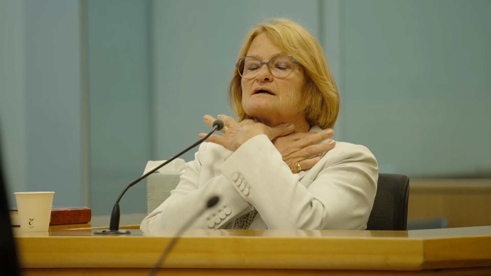 Victoria Pheasant Riordan demonstrates for the court how Pauline Hanna told her Philip Polkinghorne put his hands around her neck.