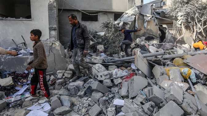 Palestinians walk among the rubble of their houses in Khan Yunis, Gaza, where the Israeli army violated the ceasefire and continued its attacks this week. Photo / Getty Images
