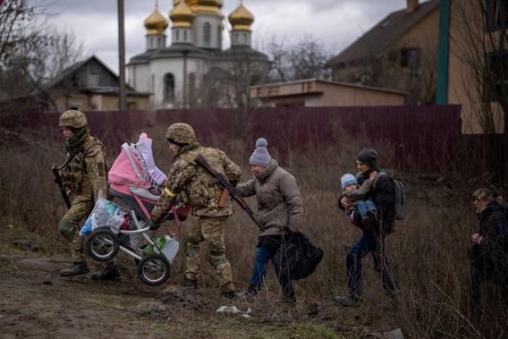 Ukrainian soldiers help a fleeing family crossing the Irpin river on the outskirts of Kyiv, Ukraine. (Photo / AP)