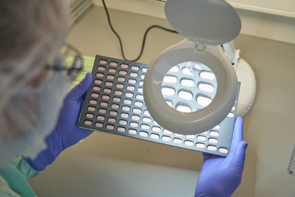 A Phizer lab technician inspects Paxlovid tablet samples in Freiburg, Germany in December. The antiviral pills are soon to be available in New Zealand. (Photo / Pfizer via AP)