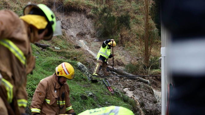 Firefighters work to clear the slip around a home in Lyttelton. Photo / George Heard