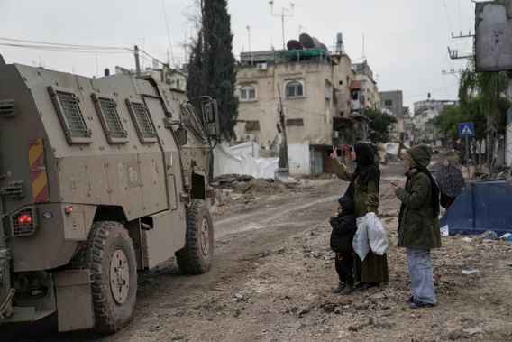A Palestinian woman flashes a V-sign towards Israeli troops during an army raid in the Tulkarem refugee camp, West Bank. Photo / AP