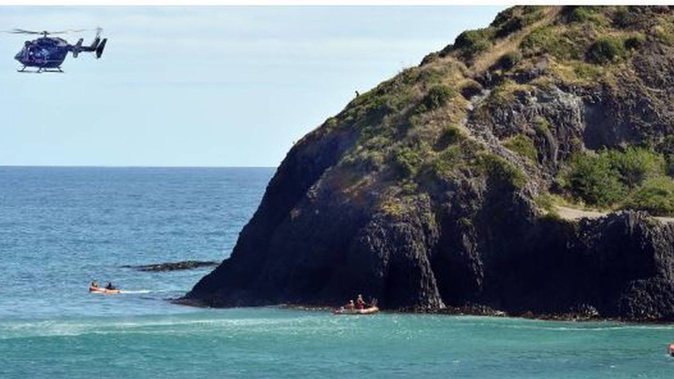 Surf life-savers, the Otago Regional Rescue helicopter crew and police on the clifftop take part in the search at Second Beach. Photo / ODT