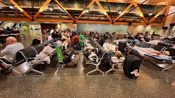 Weary travellers try to get some sleep at Auckland Airport overnight after flooded roads stranded them at the terminal. Photo / Supplied Paul Morovic - pauljmorovic@gmail.com