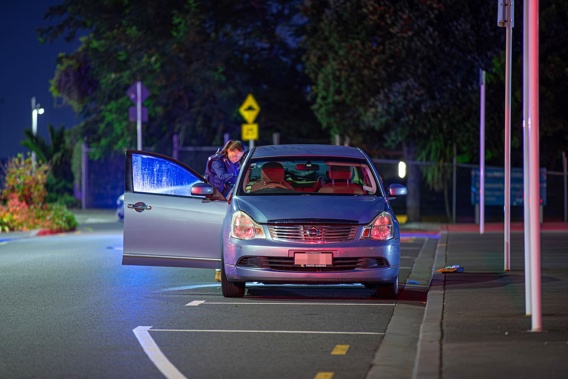 Police examine the car outside the station early this morning. Photo / Hayden Woodward