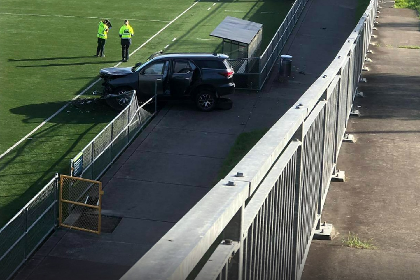 A car plunged metres on to a soccer field following a crash in Long Bay, Auckland this morning. Photo / Supplied