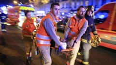 A woman is evacuated from the Bataclan concert hall after a shooting on Nov. 13, 2015. Photo / AP