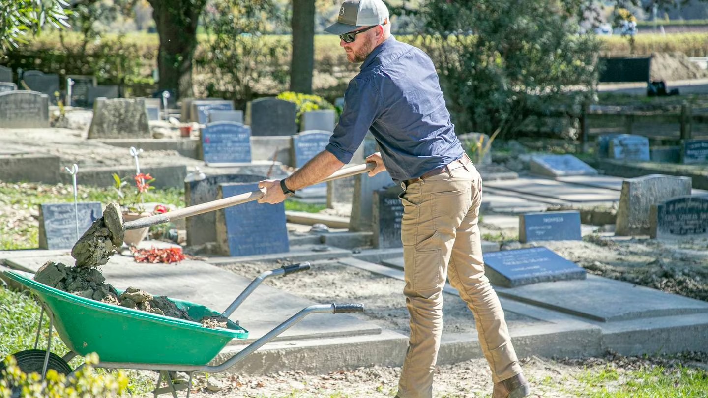 Gareth Treloar removes silt left behind after Cyclone Gabrielle from a family member's grave in Eskdale Cemetery, Napier. Photo / Warren Buckland