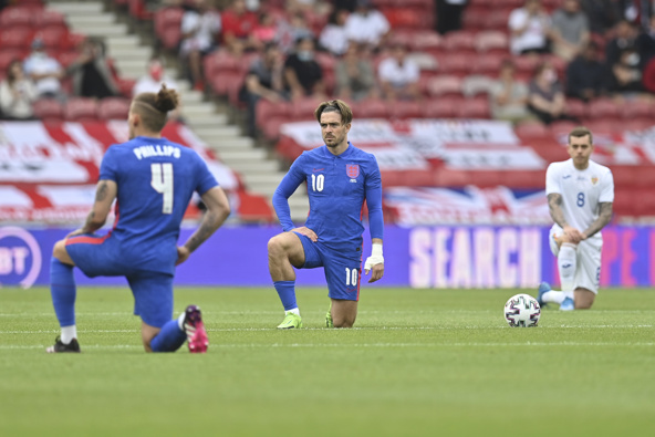 England's and Romania's players take a knee before the international friendly against Romania. (Photo / AP)
