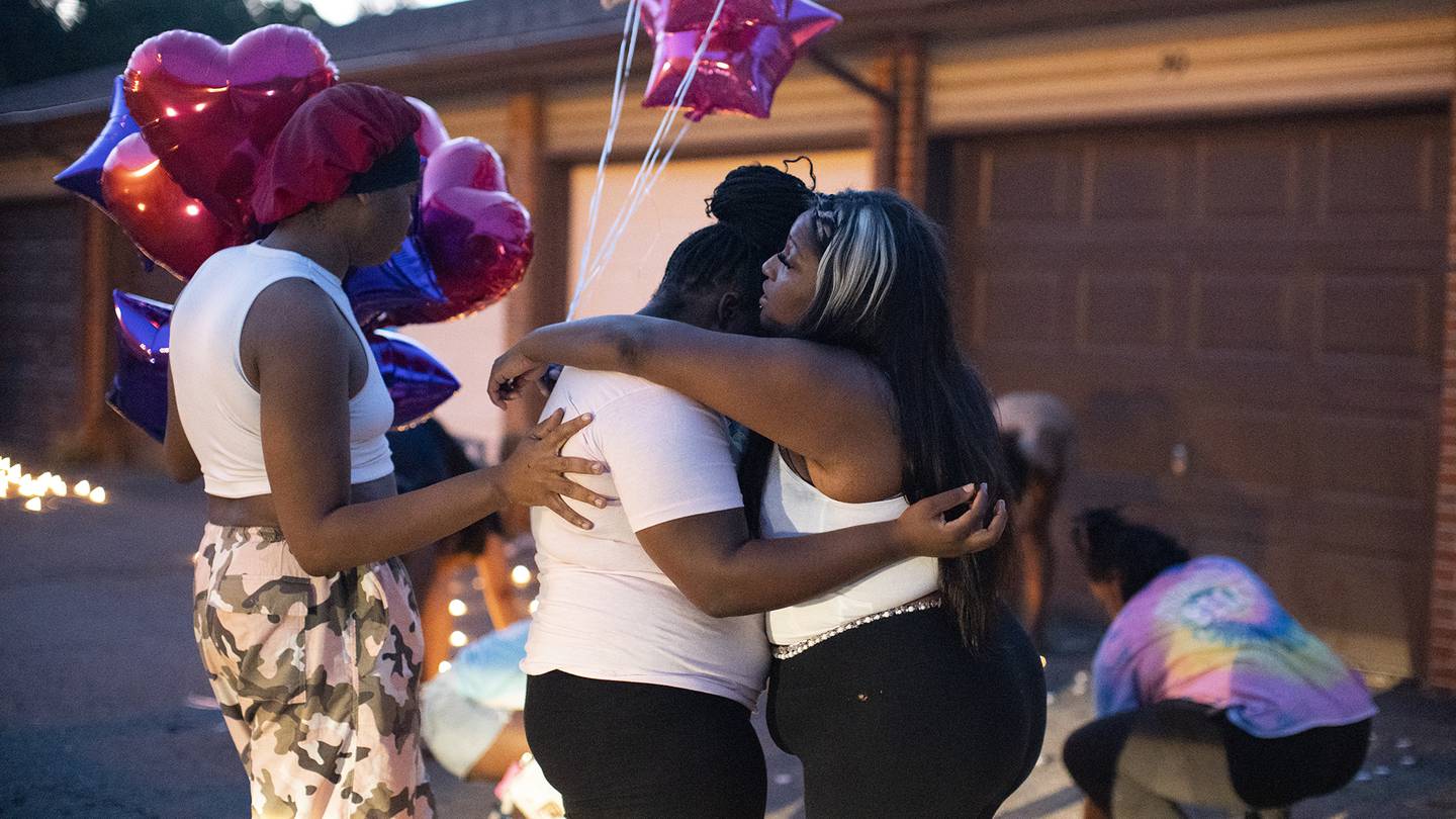 Friends comfort each other at a private candlelight vigil held for 21-year-old Ta'Kiya Young. Photo / AP