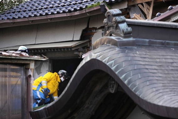 Police officers go into a building at the premises of a temple to search for victims in Wajima in the Noto peninsula. Photo / AP