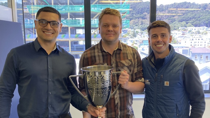 Ben Mata and Jack-Henry Sinclair join Newstalk ZB's Adam Cooper in studio with the National Football League trophy. Photo / Newstalk ZB