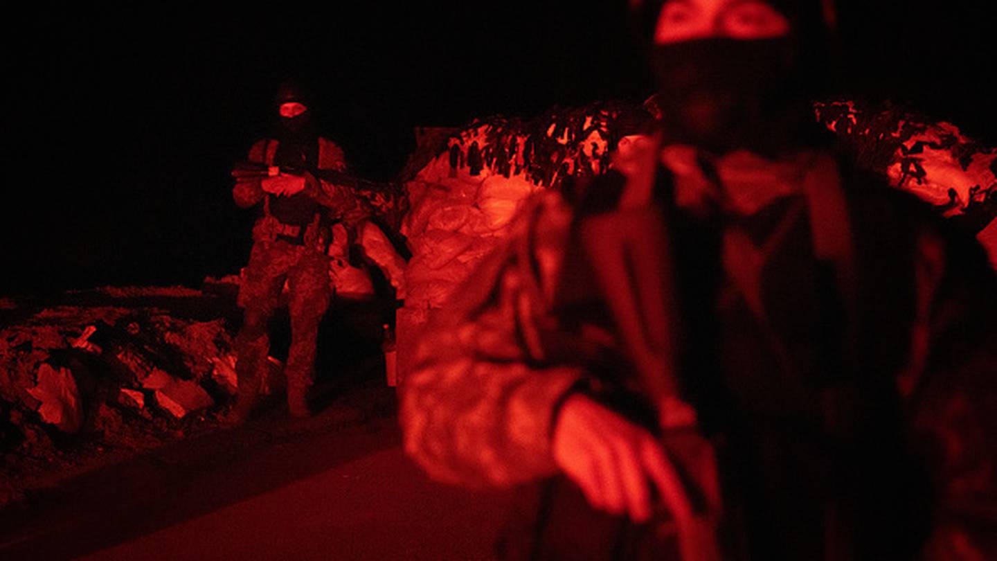 Members of the 127th Territorial Defense Force brigade search vehicles after curfew on a road on the outskirts of Kharkiv. Photo / Getty Images