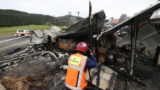 A fire inspector at the scene of the Kaihu Gas Station fire on Wednesday morning. Photo / Michael Cunningham