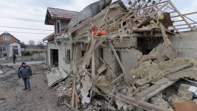A villager passes by debris of private houses ruined in Russia's night rocket attack in a village in the Zolochevsky district of the Lviv region of Ukraine on Thursday. Photo / AP