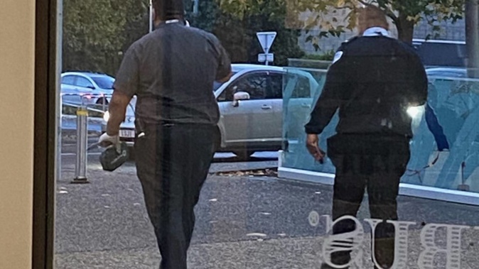 A bystander took this photo of two security guards at Sylvia Park - the guard on the left holding a large knife after reportedly disarming a man. (Photo / Supplied)