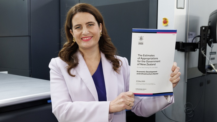 Finance Minister Nicola Willis with a copy of her Buget 2025 hot of the press at Blue Star in Petone. Photo / Mark Mitchell