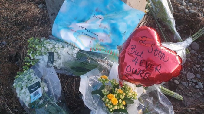 Flowers left at the scene of the crash near Timaru last August. Photo / RNZ / Conan Young
