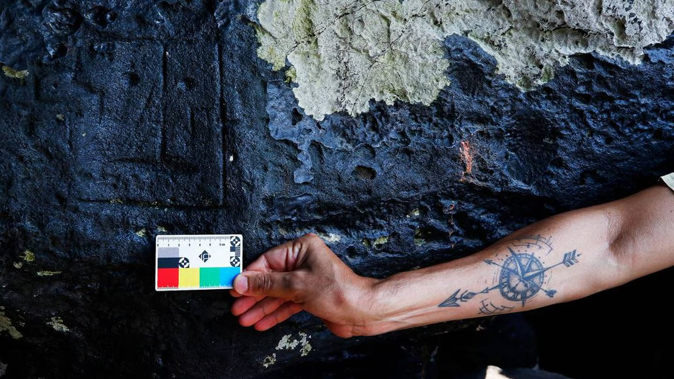 An archaeologist measures rock paintings at the Ponta das Lajes archaeological site, in the rural area of Manaus, Brazil. Photo / AP