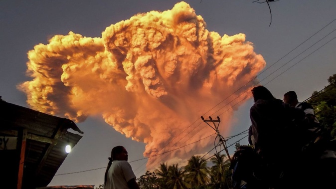 Villagers watch the eruption of Mount Lewotobi Laki-Laki as seen from Talibura village in Sikka, East Nusa Tenggara, Indonesia, last night. Photo / AFP
