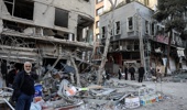 Residents stand on a street beside damaged residential buildings near Niloufar square in Tehran during the ongoing joint US-Israeli military campaign on Iran on March 2, 2026. The United States and Israel launched strikes against Iran on February 28, killing Iran's supreme leader and top military leaders, prompting authorities to retaliate with strikes on Israel and across the Gulf. (Photo by AFP)