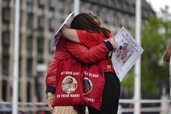 Infected blood campaigners hug during a gathering at Parliament Square, ahead of the publication of the final report into the scandal, in London, Sunday, May 19, 2024. The final report of the U.K.’s infected blood inquiry will be published Monday, six years after it started its work. The inquiry heard evidence as to how thousands of people contracted HIV or hepatitis from transfusions of tainted blood and blood products in the 1970s and 1980s. (Aaron Chown/PA via AP)