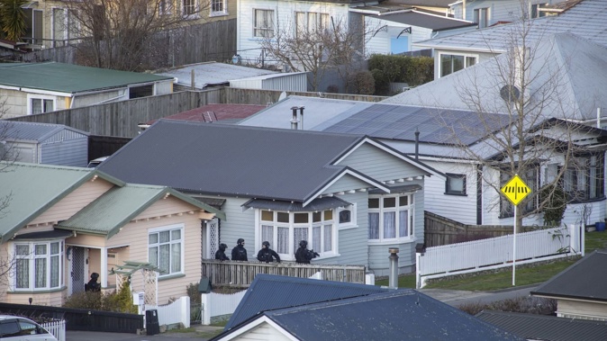 AOS members wait in a neighbouring property during the hostage situation at a house in Motueka St, Nelson on Monday. Photo / Tim Cuff