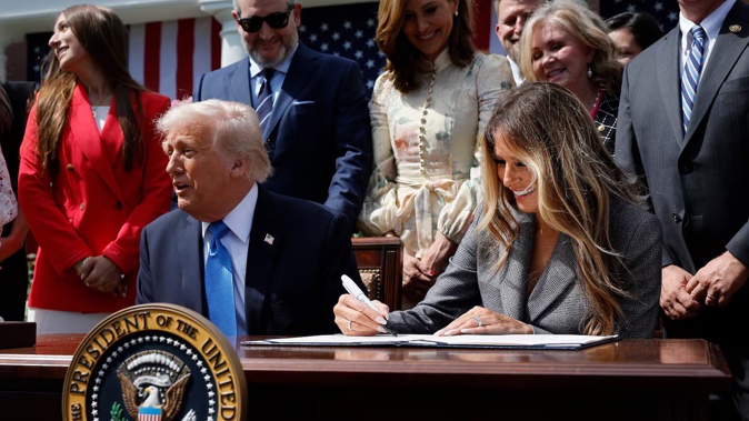 First lady Melania Trump signs the TAKE IT DOWN Act alongside US President Donald Trump, lawmakers and victims of AI deepfakes and revenge porn. Photo / Getty Images