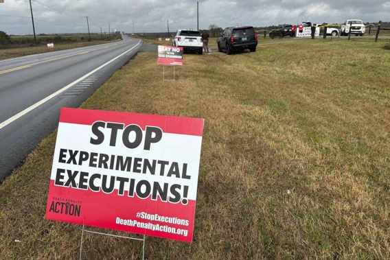 Anti-death penalty activists place signs along the road heading to Holman Correctional Facility in Atmore. Photo / AP