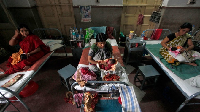 Mothers hold their newborn babies inside a maternity hospital during "World Population Day" in Kolkata July 11, 2012. Rupak De Chowdhuri/Reuters/FILE
