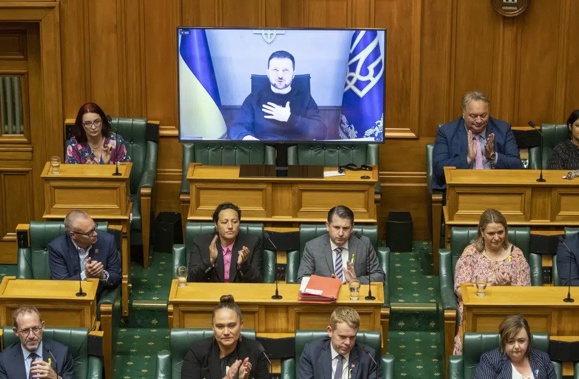 Ukrainian President Volodymyr Zelenskyy appears via video during his address to the New Zealand Parliament in Wellington Wednesday, Dec. 14, 2022. Zelenskyy urges New Zealand to take a leading role in focusing on the environmental destruction his country is suffering as a result of Russia's invasion. (Mark Mitchell/New Zealand Herald via AP)