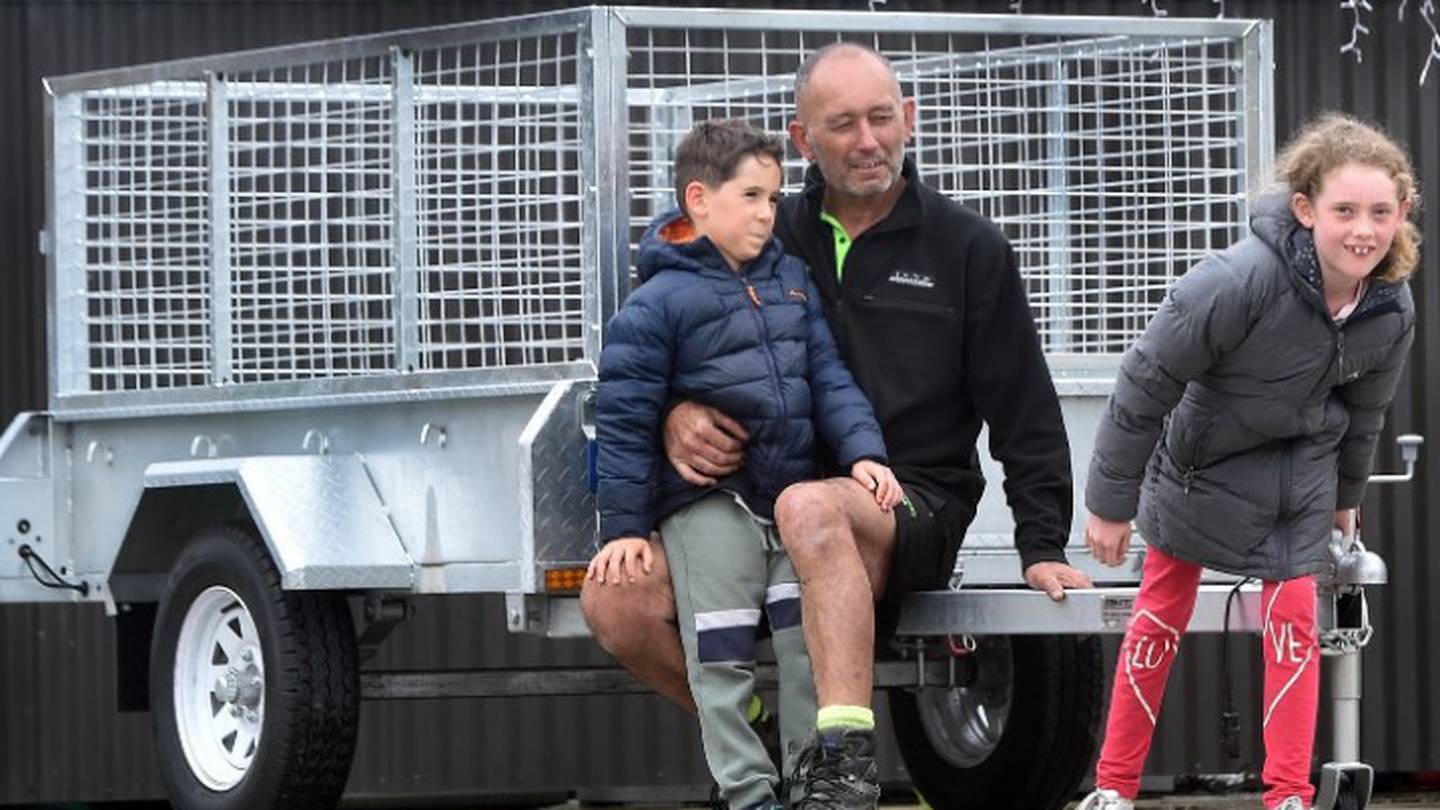 Shane Maaka with grandchildren Greg and Leah Maaka and the trailer he recently won in the Otago Community Hospice raffle. Photo / Peter McIntosh