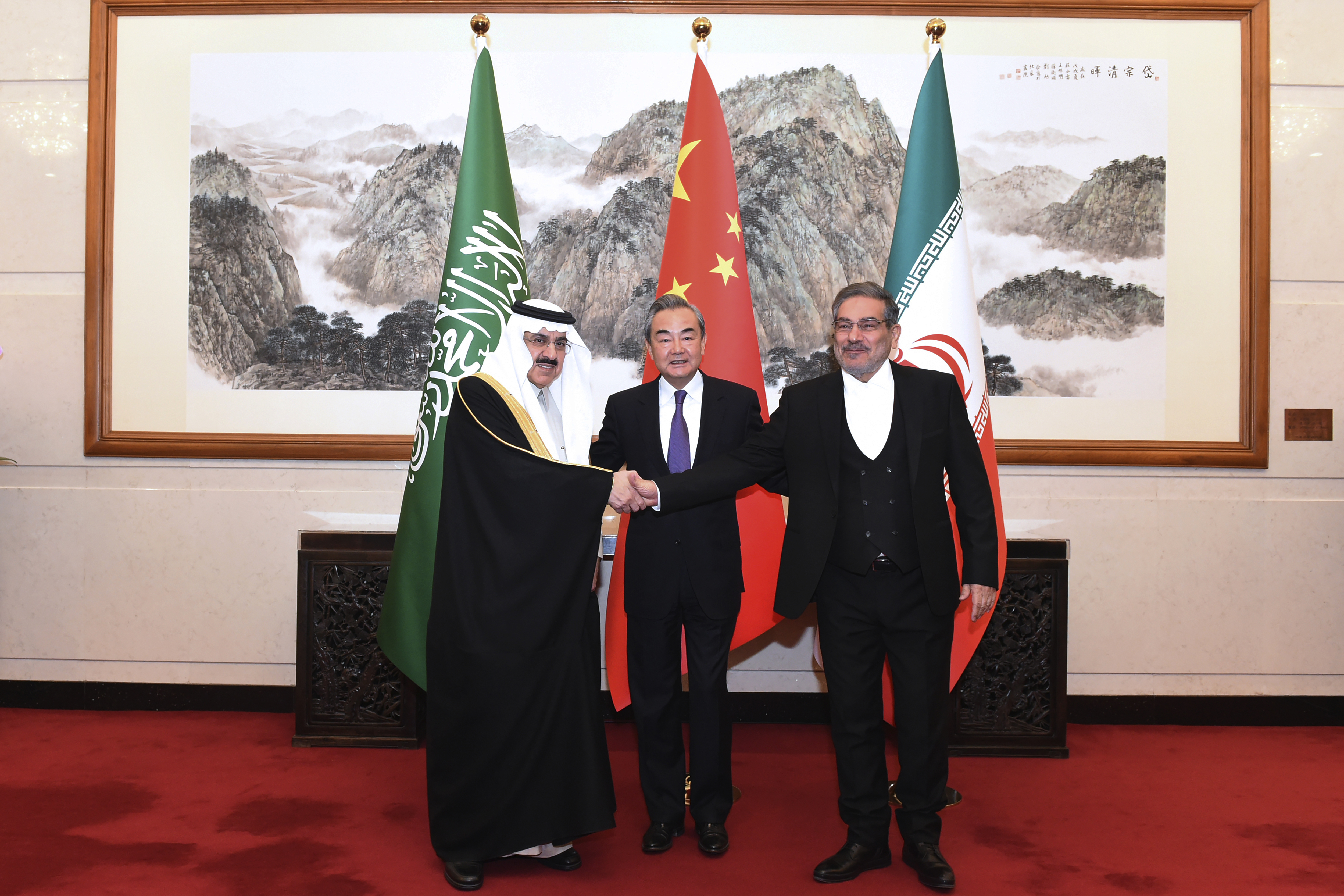 In this photo released by Xinhua News Agency, Ali Shamkhani, the secretary of Iran's Supreme National Security Council, at right, shakes hands with Saudi national security adviser Musaad bin Mohammed al-Aiban, at left, as Wang Yi, China's most senior diplomat, looks on, at center, for a photo during a closed meeting held in Beijing, Saturday, March 11, 2023. Photo via AP