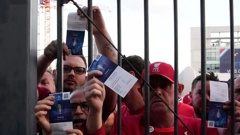 Fans shows tickets in front of the Stade de France prior the Champions League final soccer match between Liverpool and Real Madrid, in Saint Denis near Paris, Saturday, May 28, 2022. (Photo / AP)