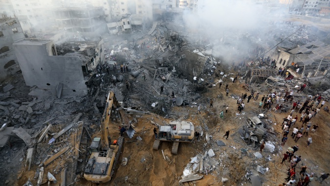 Palestinians inspect the damage of destroyed buildings following Israeli airstrikes on Gaza City. Photo / AP