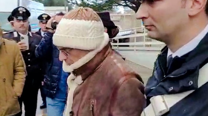 Top Mafia boss Matteo Messina Denaro, centre, leaves an Italian Carabinieri barrack soon after his arrest at a private clinic in Palermo, Sicily, after 30 years on the run. Photo / Carabinieri via AP