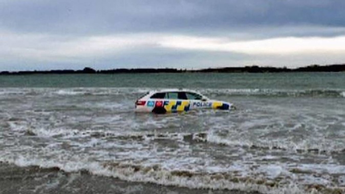 A police car stuck at Oreti Beach in Invercargill. Photo / Supplied