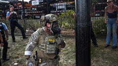 A US Customs and Border Protection agent holds a cannister as demonstrators protest along Kedzie Avenue in Chicago yesterday. Photo / Joshua Lott, The Washington Post