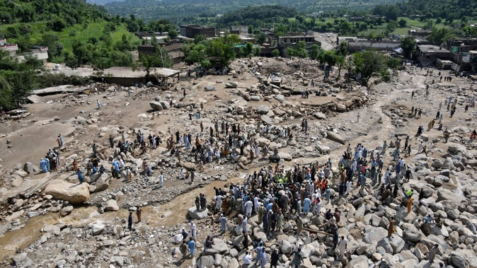 An aerial view shows flood survivors gathered near damaged houses along the banks of a river surrounded by heavy rocks in the Buner district of mountainous Khyber Pakhtunkhwa province on August 17, 2025. Photo / Abdul Majeed, AFP
