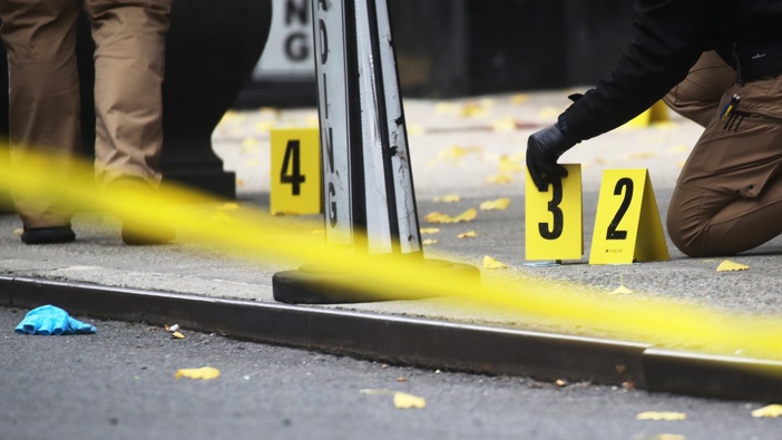 Police place bullet casing markers outside of a Hilton Hotel in Midtown Manhattan where United Healthcare CEO Brian Thompson was fatally shot. (Photo by Spencer Platt/Getty Images)