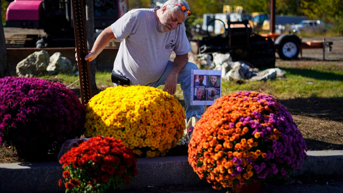 Richard Morlock, a member of the deaf community and surviver of the mass shooting at Schemengees Bar and Grille, pays his respect at a makeshift memorial to his friends. Photo / AP