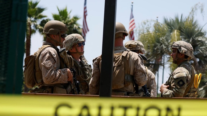 US Marines chat with members of the National Guard at one of the entrances to the Wilshire Federal Building in Los Angeles, California, in June. Los Angeles has been at the centre of political flashpoints this year over federal law enforcement, immigration, and redistricting. Photo / Etienne Laurent, AFP