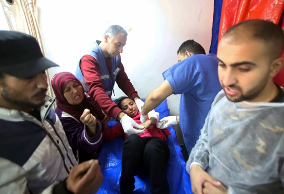 Palestinian medics treat a girl wounded in the Israeli bombardment at a building of an UNRWA vocational training center which displaced people use as a shelter in Khan Younis, southern Gaza Strip. Photo / AP