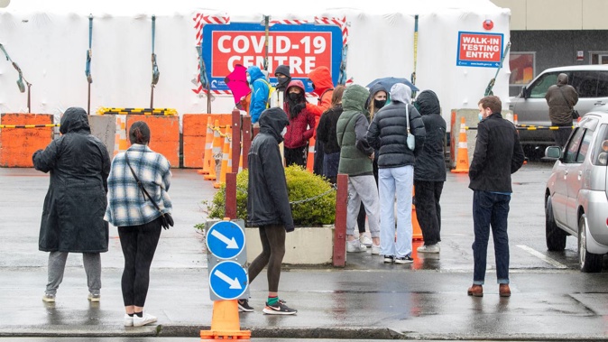 People wearing masks waiting to be tested at the Taranaki St Covid-19 testing station in Wellington. (Photo / Mark Mitchell)